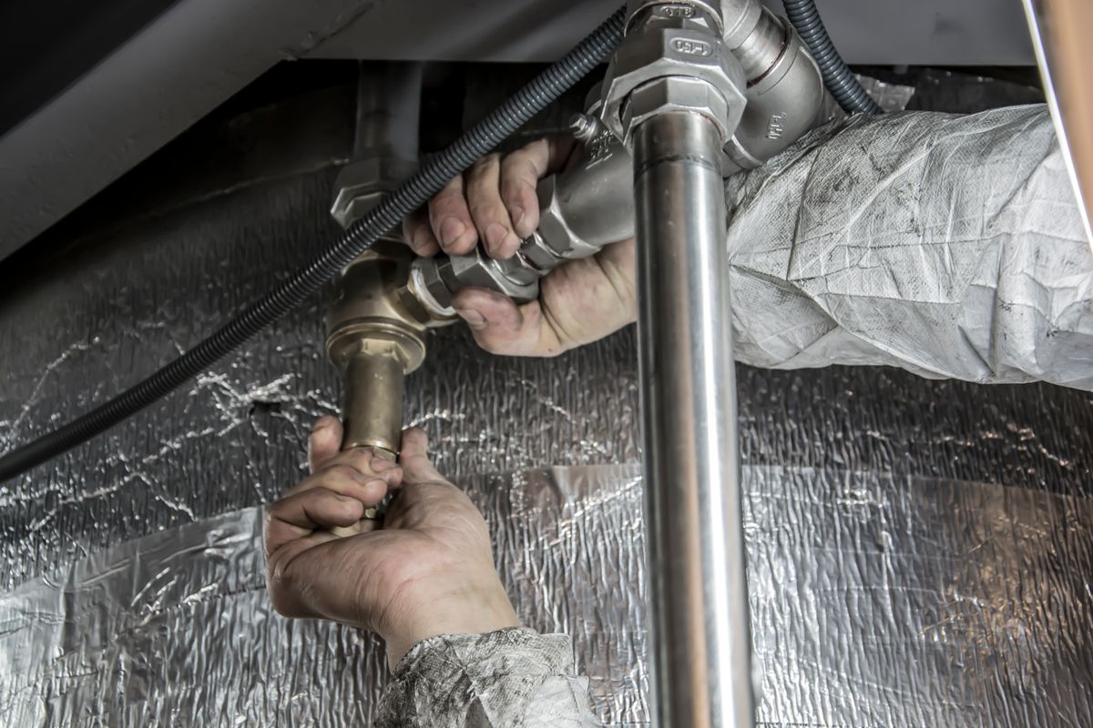 Installateur montiert Rohranschluss — Sanitärinstallation